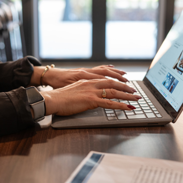 An employee types on a laptop keyboard