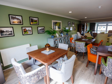 A modern and refurbished dining area with tables and chairs in a kitchen