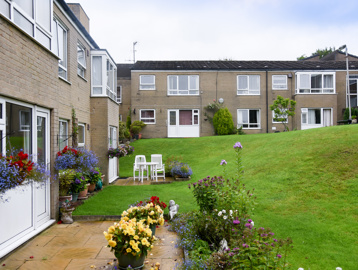 Communal gardens with patio areas, plants and flowers, and sloped grassed area