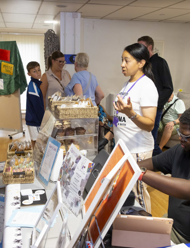 MP Sureena Brackenridge speaks to a stall owner who is selling cupcakes 