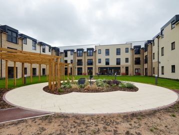 Large communal garden area with plants and large circular patio area in the centre