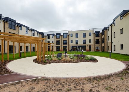 Large communal garden area with plants and large circular patio area in the centre