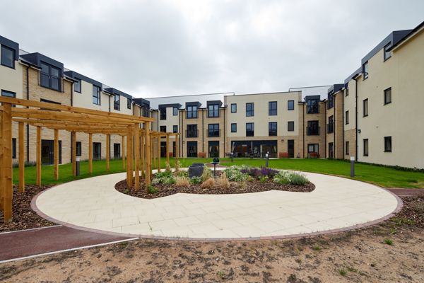 Large communal garden area with plants and large circular patio area in the centre
