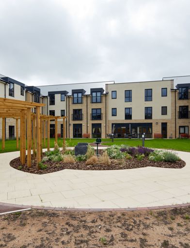 Large communal garden area with plants and large circular patio area in the centre 