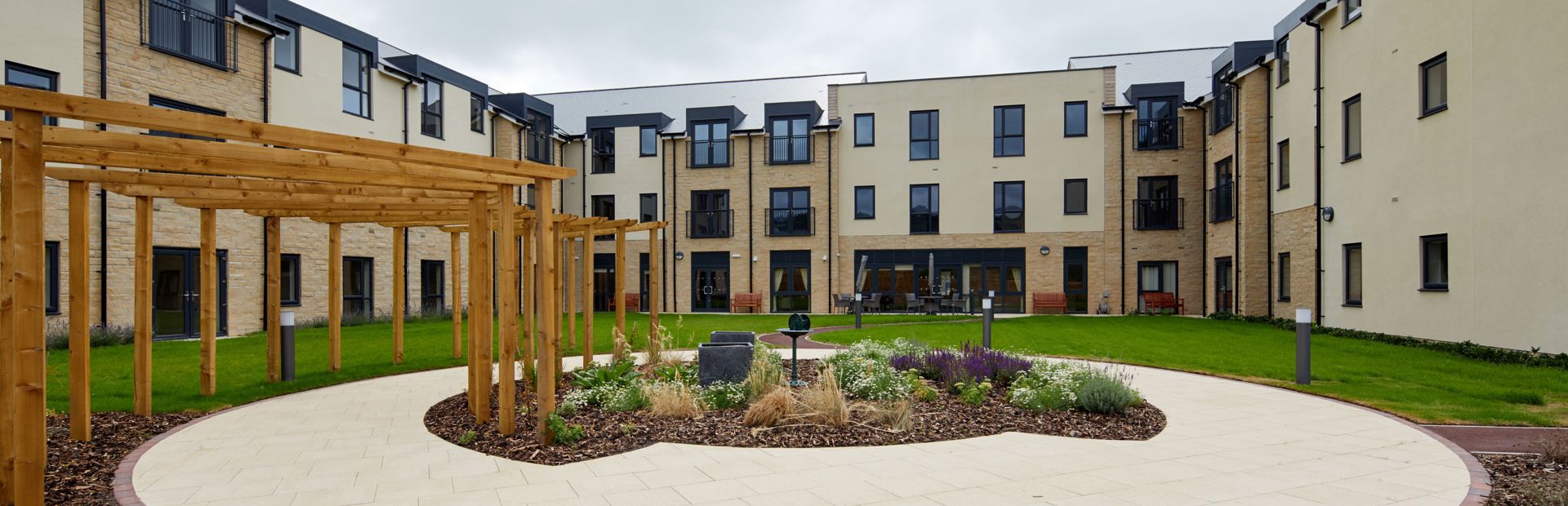 Large communal garden area with plants and large circular patio area in the centre