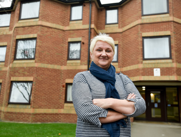 Female stood outside the front of the entrance to Acre Court