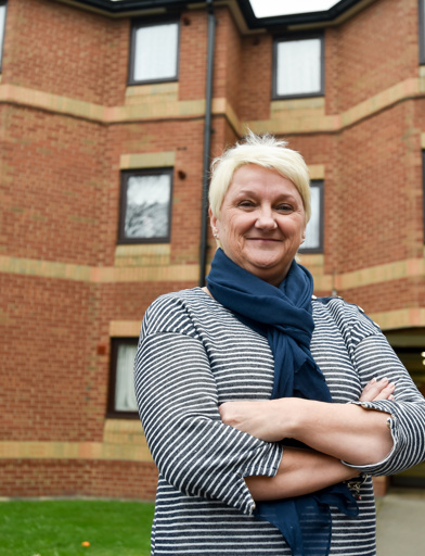 Female stood outside the front of the entrance to Acre Court