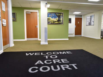 Large mat inside the entrance at Acre Court displaying the name of the scheme