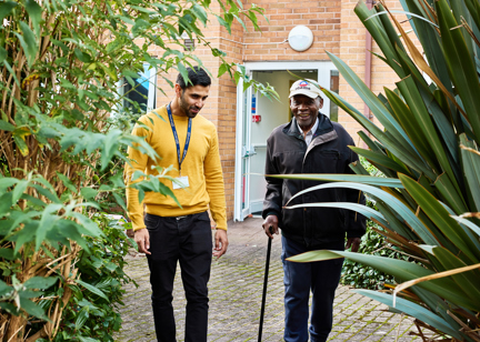 Resident and employee walking in the garden