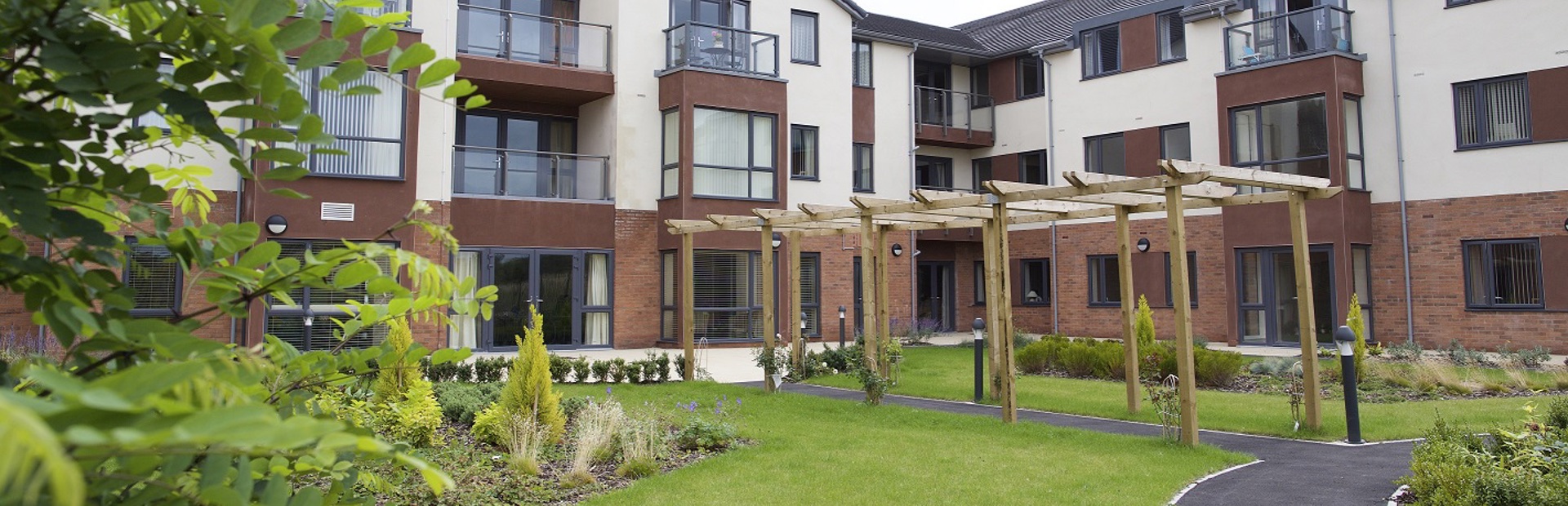 Curved path through a grassed section and veranda in the rear garden