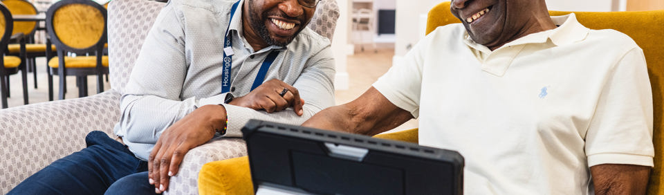 Resident and employee sitting down using a laptop 