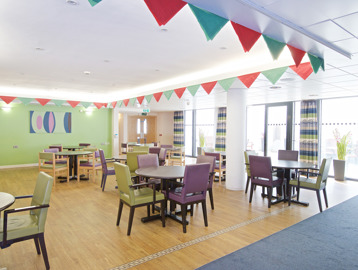 Communal dining room with wooden flooring and carpet