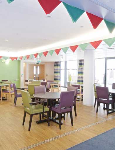 Communal dining room with wooden flooring and carpet
