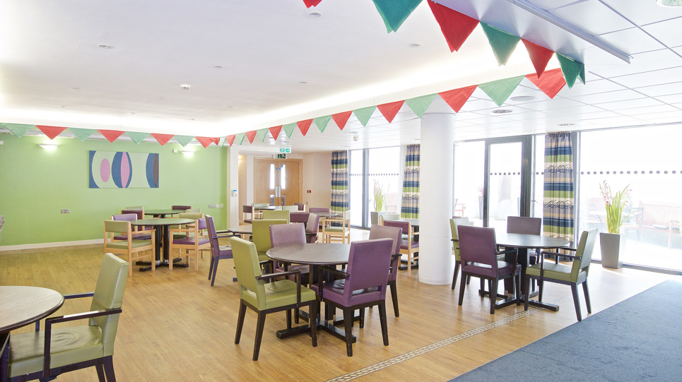 Communal dining room with wooden flooring and carpet
