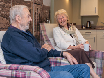 Resident and Housing 21 employee chatting on sofas