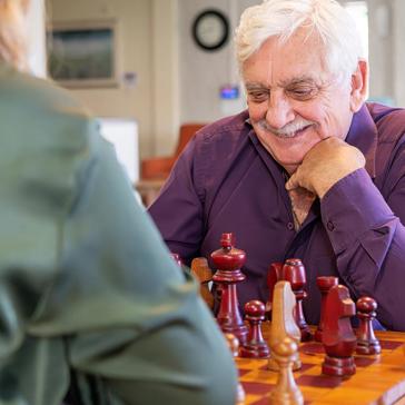 Two residents enjoying a game of chess in a communal area