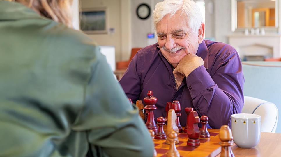 Two residents enjoying a game of chess in a communal area