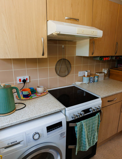 Kitchen with fitted units, storage space, washing machine, small double oven, and standing fridge freezer. 