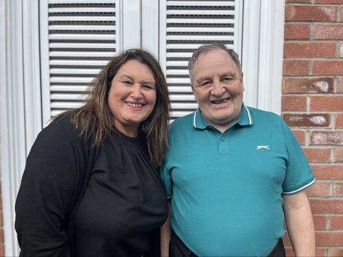 Catherine Local Housing Manager with resident Howard outside a door smiling