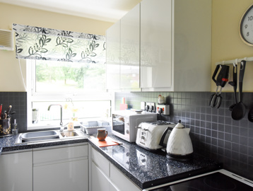 Inside the kitchen of an apartment with utensils and small appliances on show