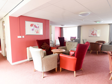 Red and grey themed communal lounge area with soft seating