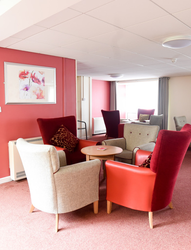 Red and grey themed communal lounge area with soft seating