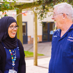 Two Care Workers smiling outside in a garden
