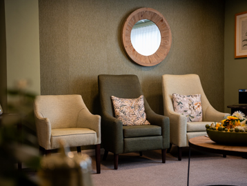 Cream and green comfy chairs in the communal lounge