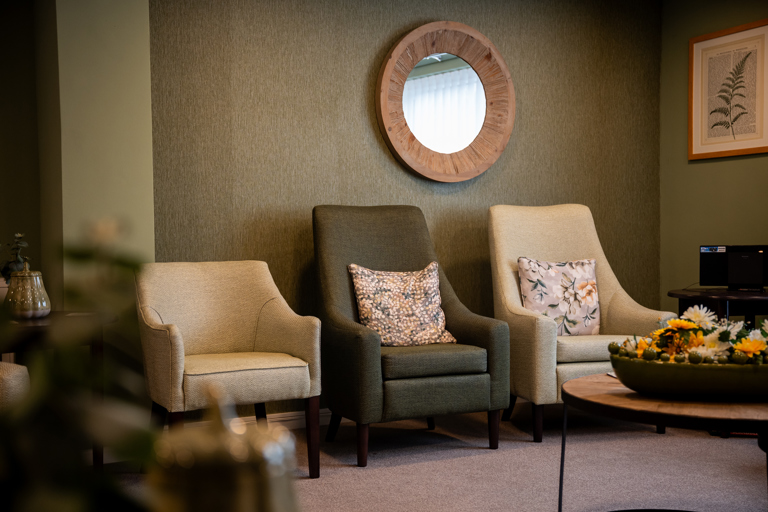 Cream and green comfy chairs in the communal lounge
