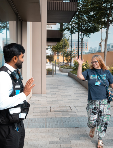 Resident Jane waving to a Security Guard in White City Living as she walks away from Minterne Apartments 