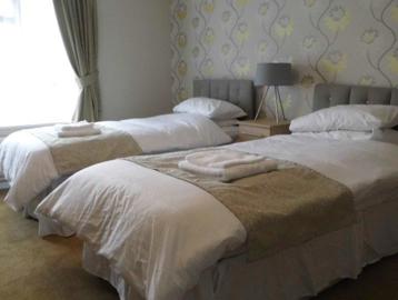 The guest room with two single beds at Absalom Court
