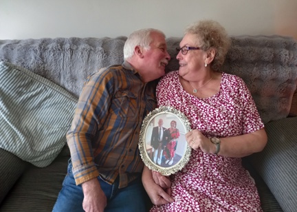 Residents leaning in on a sofa holding a photo