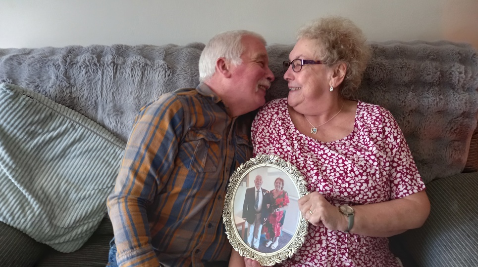 Residents leaning in on a sofa holding a photo