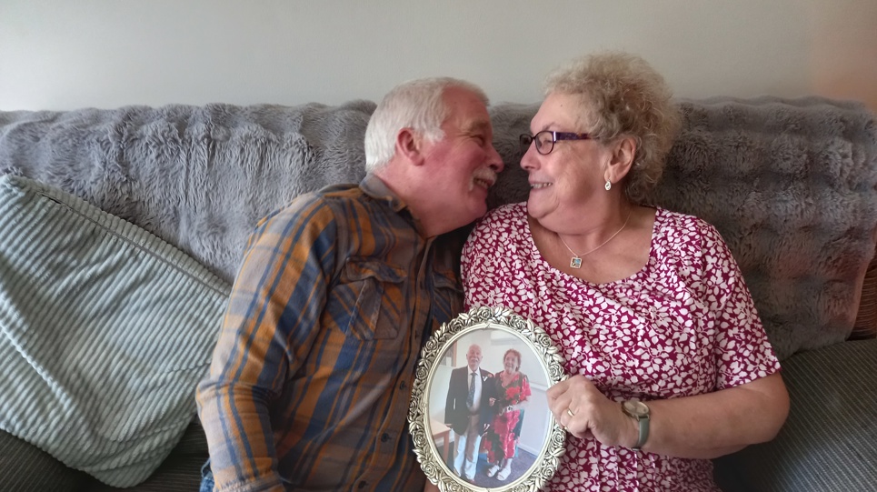 Residents leaning in on a sofa holding a photo