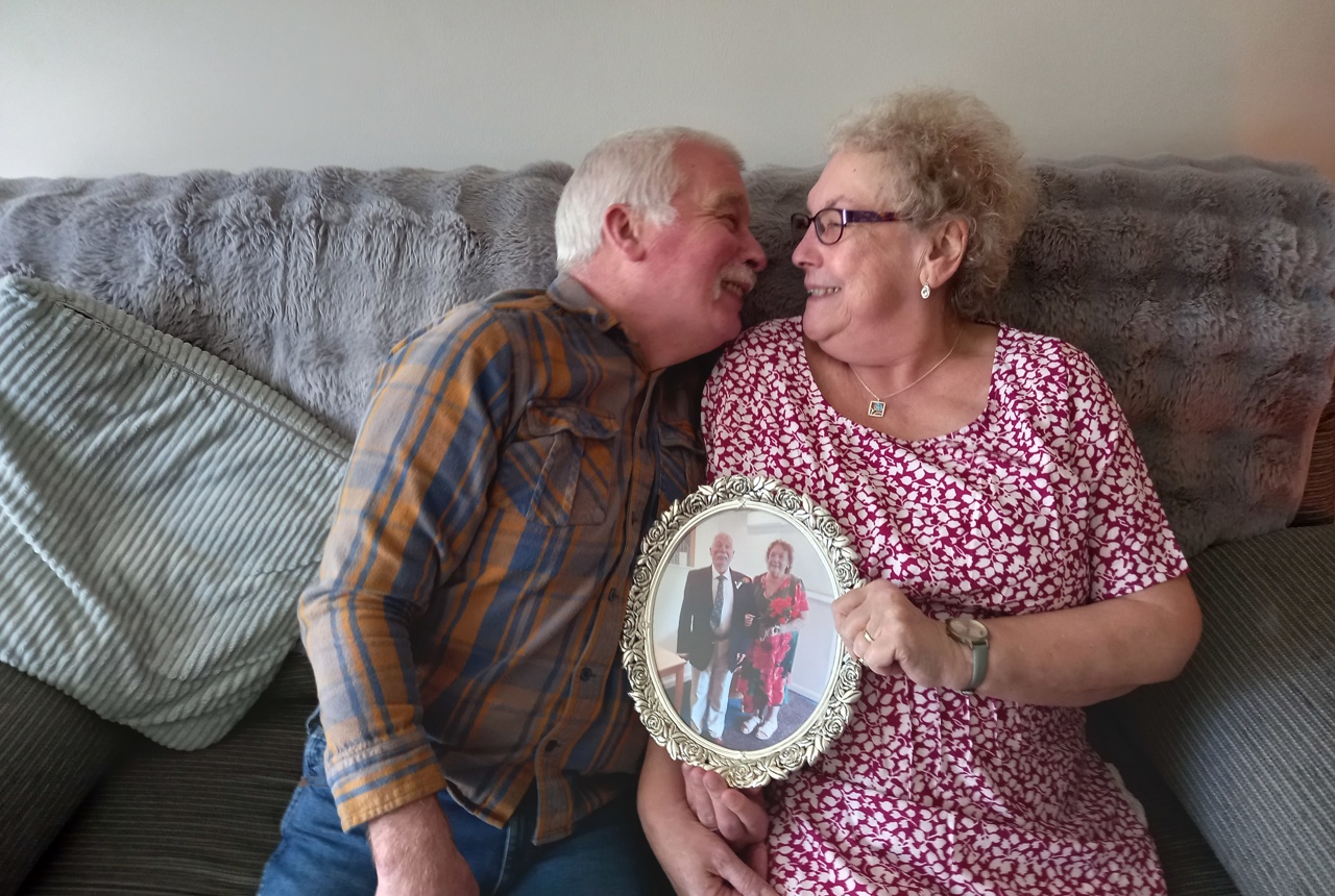 Residents leaning in on a sofa holding a photo