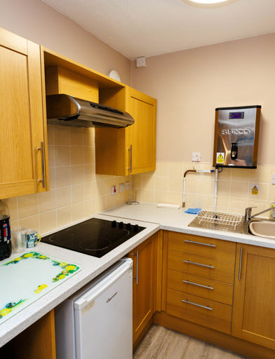 Kitchen area with oven, tabletop hob, cupboards and preparation areas 