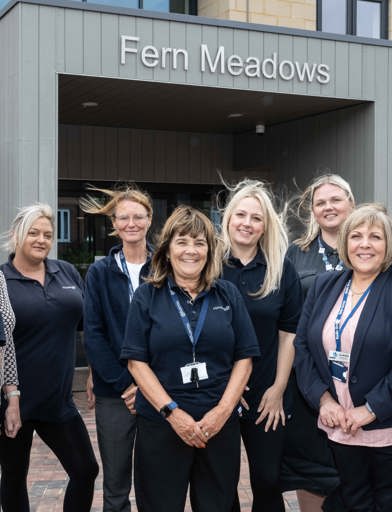 A group of Housing 21 colleagues positioned at the front entrance outside Fern Meadows 