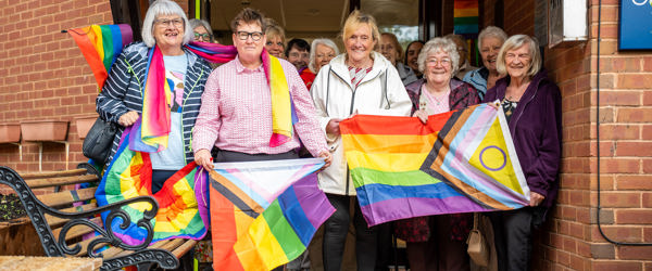 People wave LGBTQ+ flags 