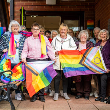 People wave LGBTQ+ flags 