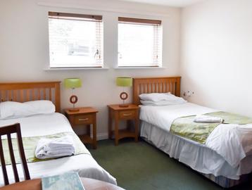 A bedroom with two single beds and furniture