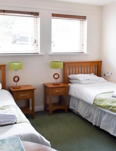 A bedroom with two single beds and furniture