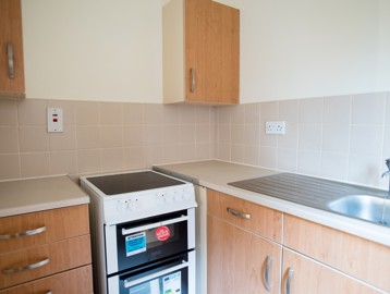 Small section of kitchen with sink area, worktops and oven