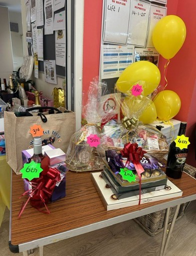 A photo of different prizes including bottled drinks, chocolates, and hampers 