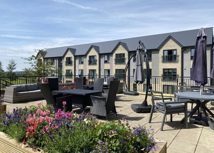 A photo of the large patio area at Castlestead View overlooking the garden on a sunny day