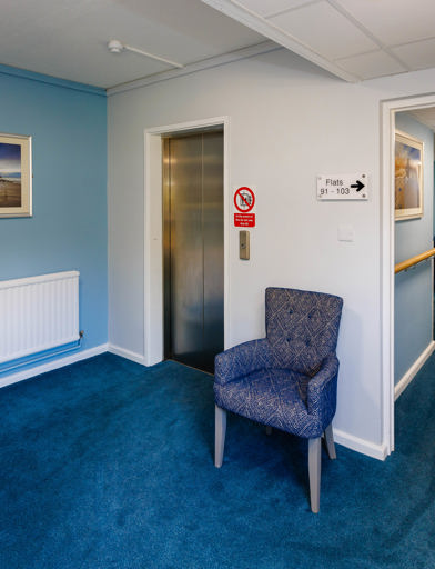 Hallway with elevator and armchair waiting area 