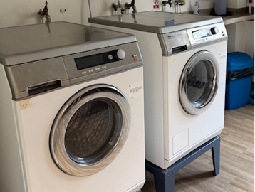 Two washing machines in a laundry room
