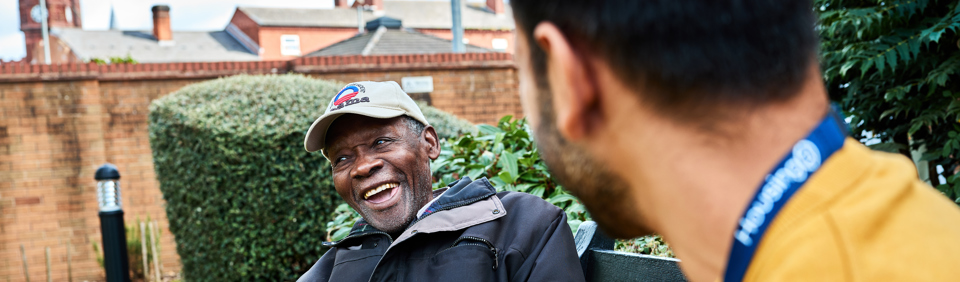 Resident and employee in the garden smiling 