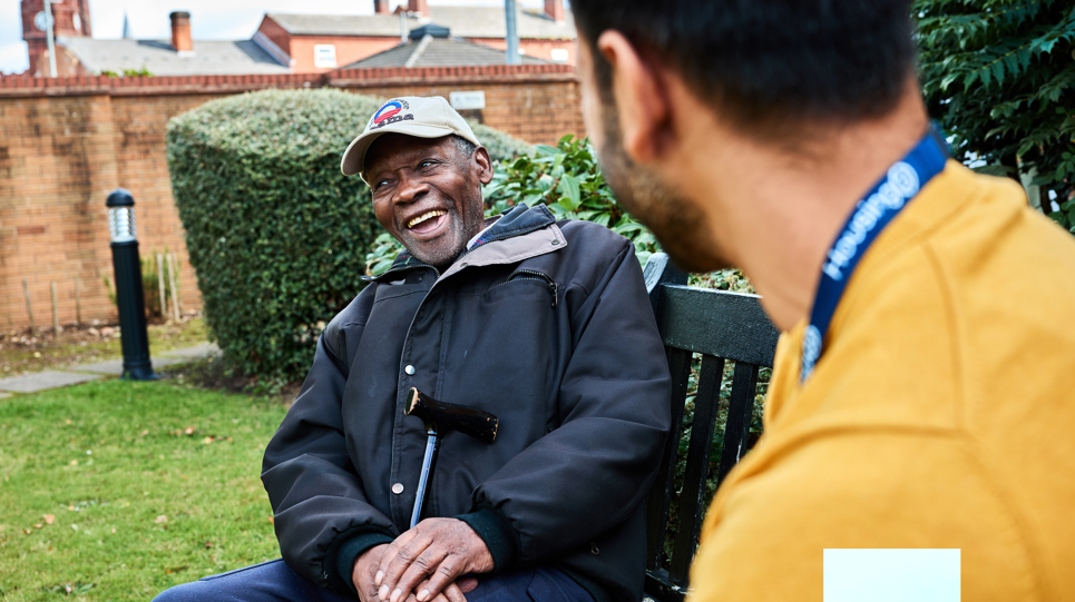 Resident and employee in the garden smiling