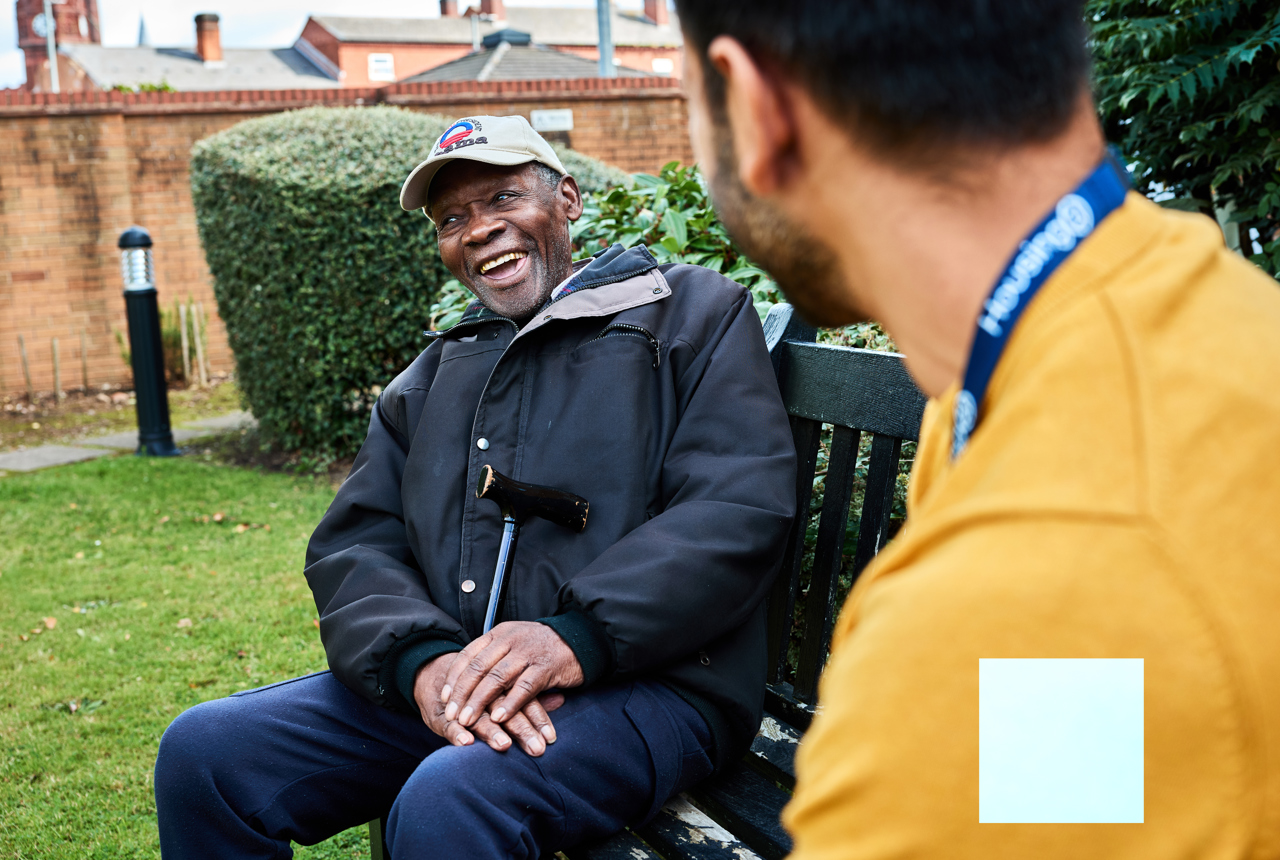 Resident and employee in the garden smiling