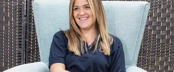 A Housing 21 employee smiling whilst sitting in a chair